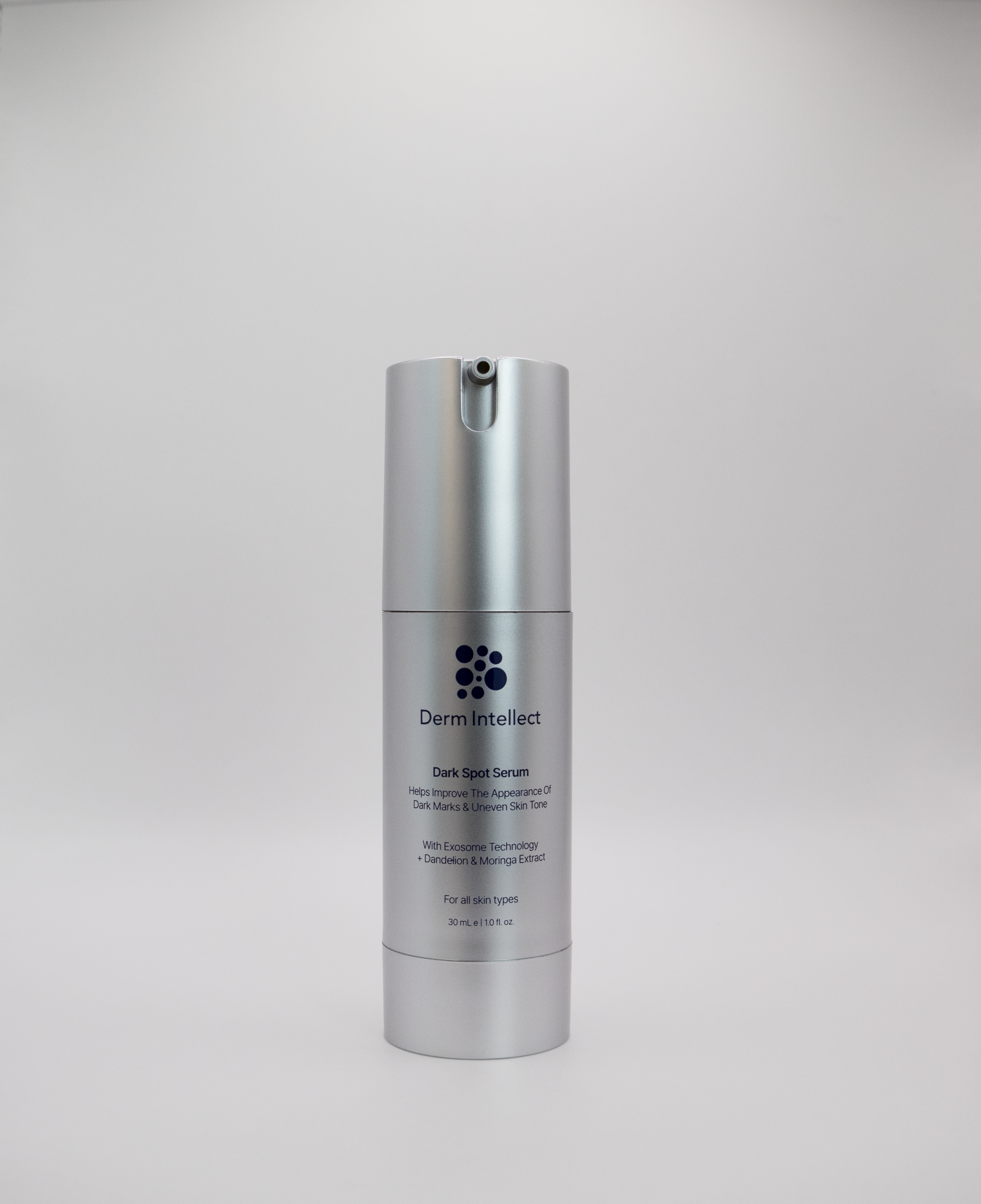 Derm intellect Dark Spot Serum in a sleek silver cylindrical pump bottle, centered against a neutral light gray background.